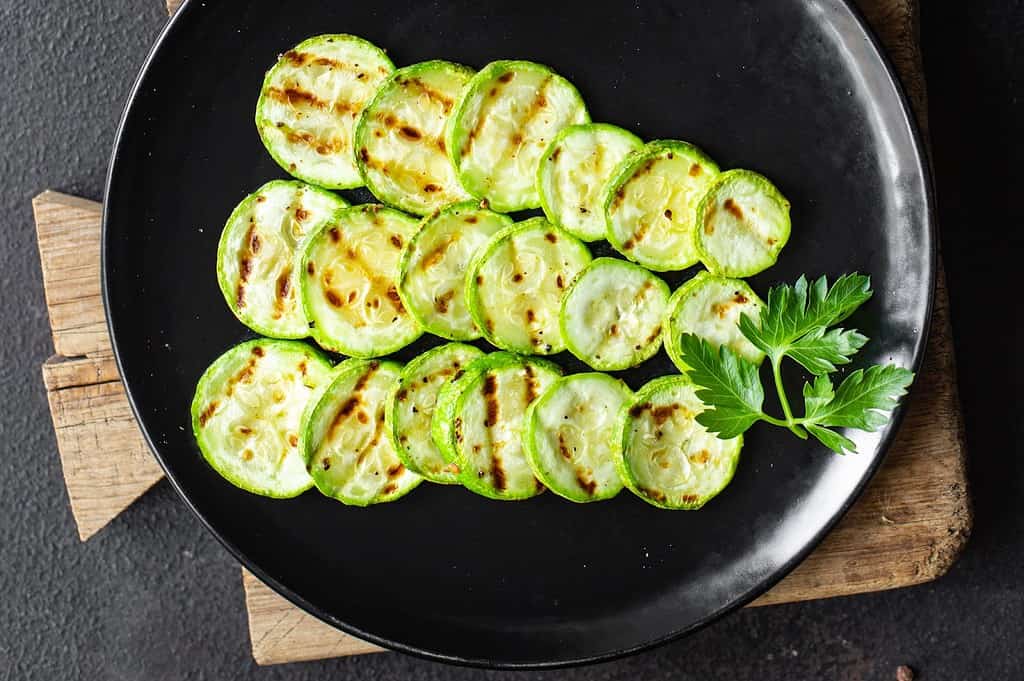 Healthy grilled zucchini slices served on a black plate for nutritious meals.