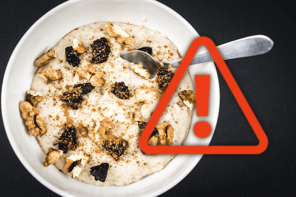 Image showing a bowl of creamy dog-safe dessert with nuts and dried berries on a black background, with caution warning overlay.