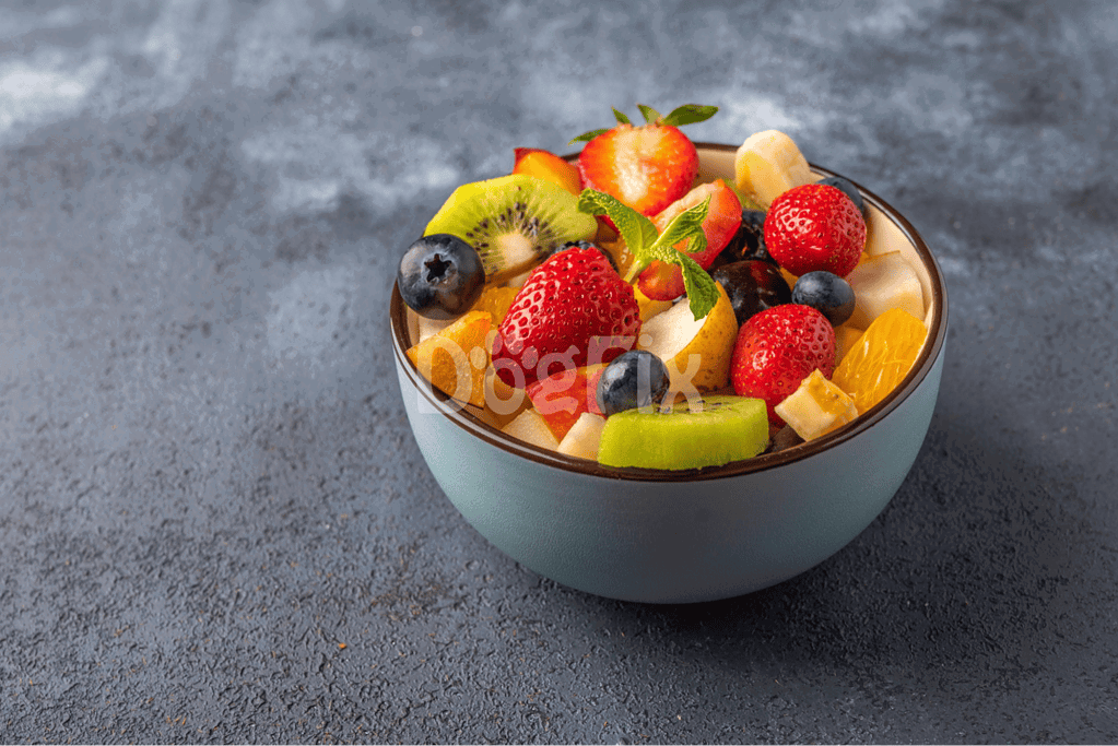 Healthy fruit salad with strawberries, blueberries, kiwi, and oranges for dogs' nutrition.