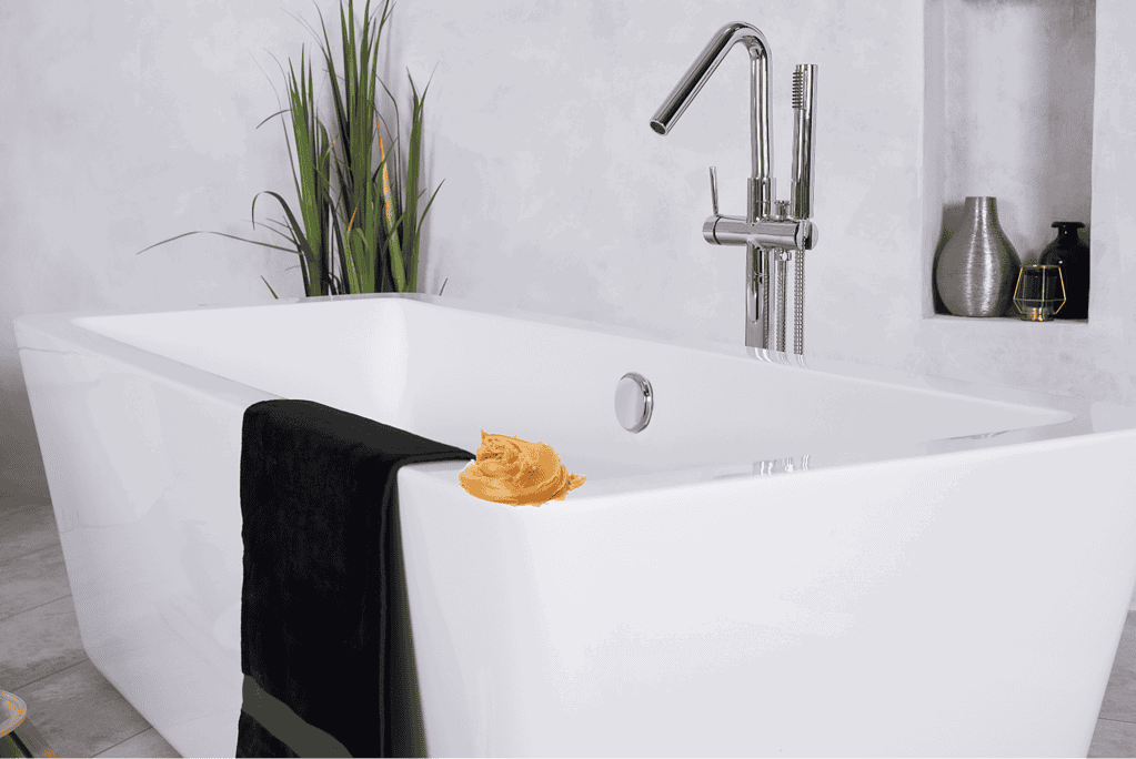Modern bathroom tub with sleek chrome fixture, black towel, and decorative vases.