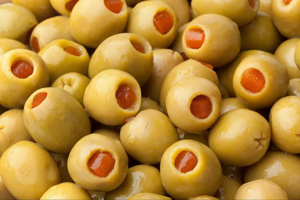 Delicious stuffed green olives filled with bright red pimentos, perfect for appetizers or snacks.