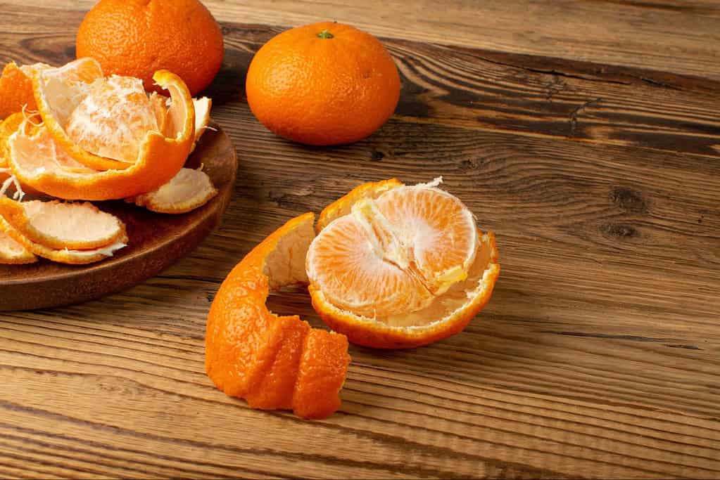 Orange citrus fruit with peel and segments, healthy snack option.