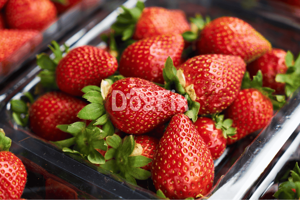 Close-up of ripe, juicy strawberries in a plastic container, highlighting healthy fruit options for dogs.