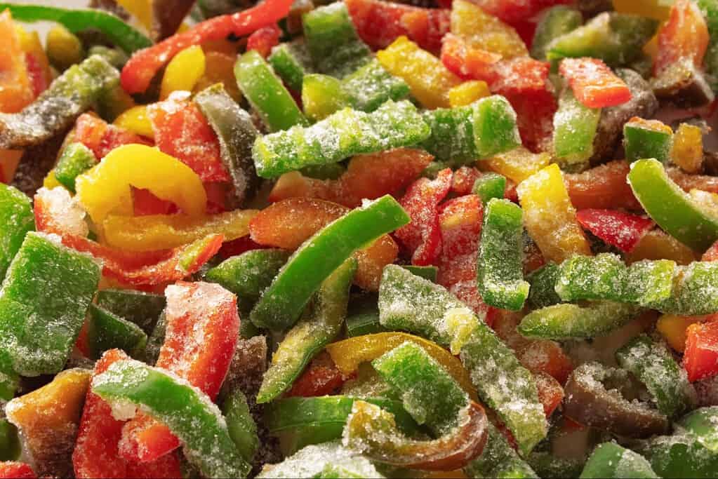 Fresh frozen dog vegetables with vibrant red, green, yellow, and orange colors, perfect for pet meals.