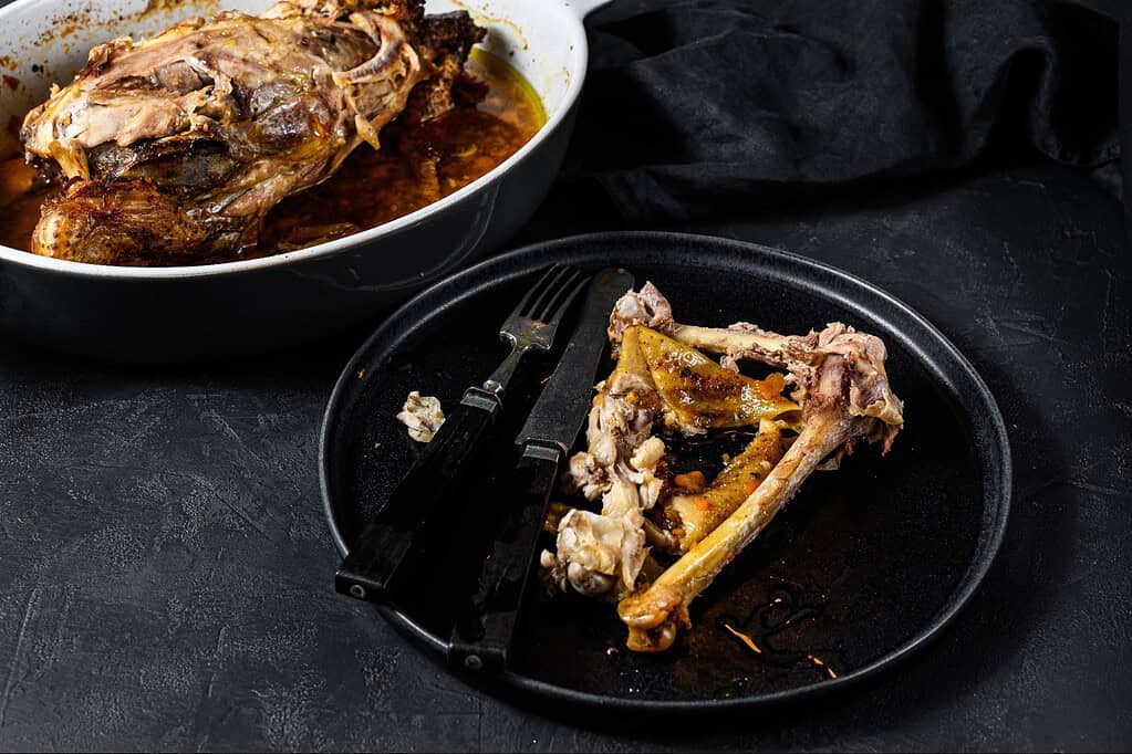 Tender lamb bones and meat in a black dish, perfect for nutritious dog food.