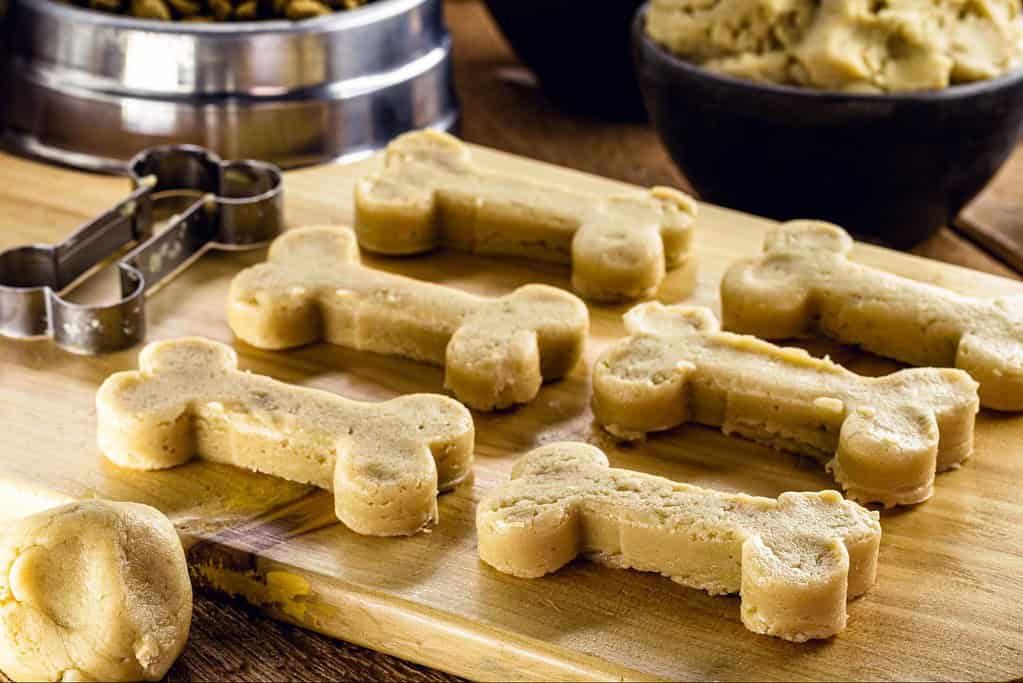 Delicious homemade dog cookies shaped like bones on a wooden surface. Perfect treats for your furry friend.