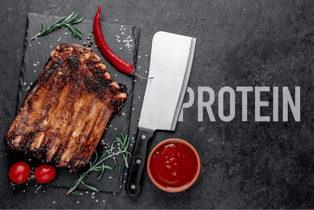 Delicious grilled pork ribs with seasoning, chili, and side sauce, perfect for protein-rich meals.