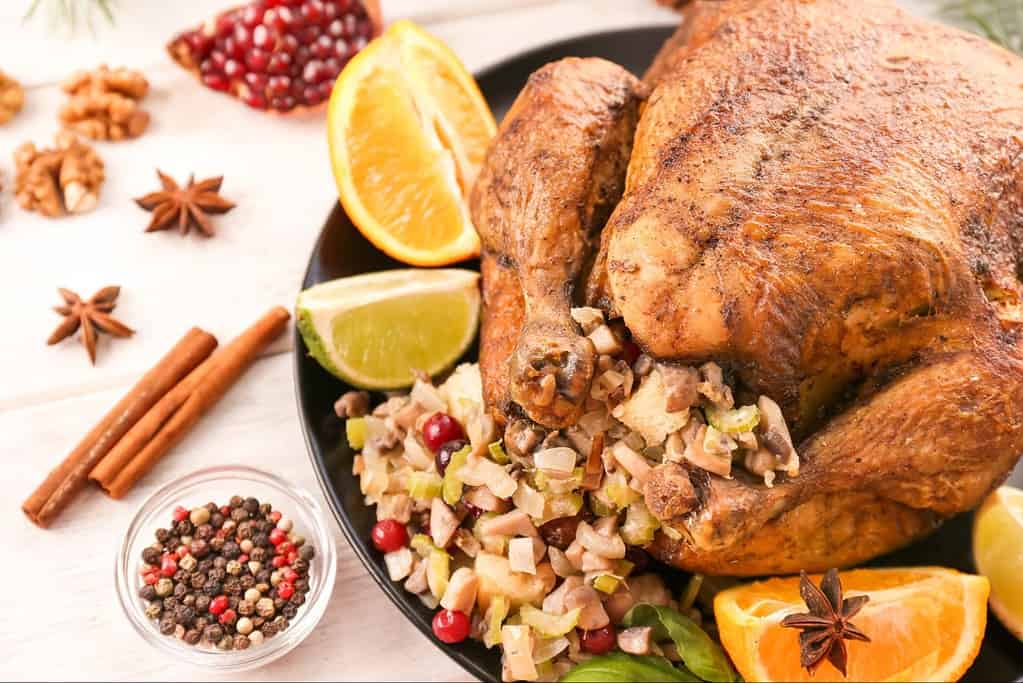 Juicy roasted turkey served with orange, lemon, and traditional stuffing on festive table.