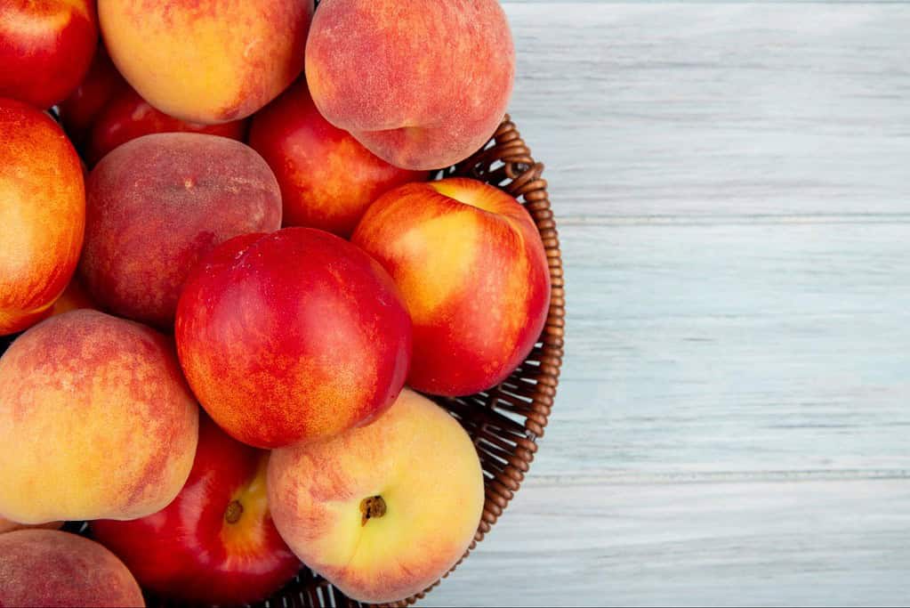 Fresh peaches in a woven basket for healthy snacking.