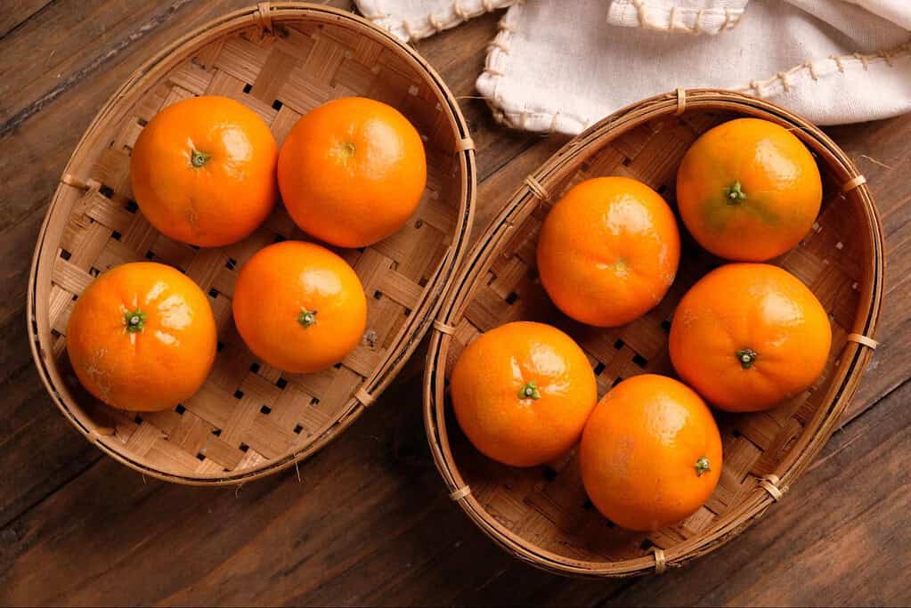 Bright fresh oranges in small woven baskets, perfect for healthy snacks and fruit baskets.