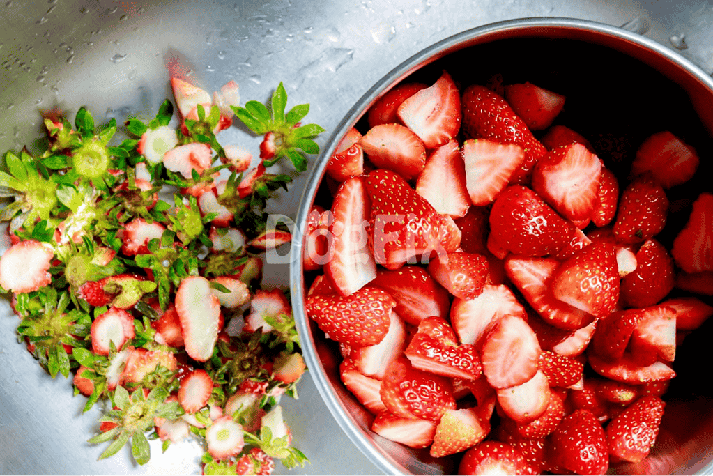 Bright red strawberries chopped and whole, ripe and ready for snacking or dessert preparation.