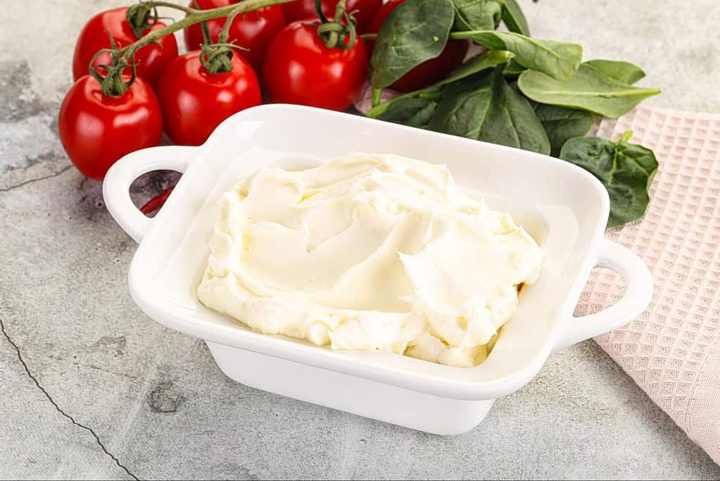 Close-up of creamy cheese spread with smooth texture and swirled appearance.