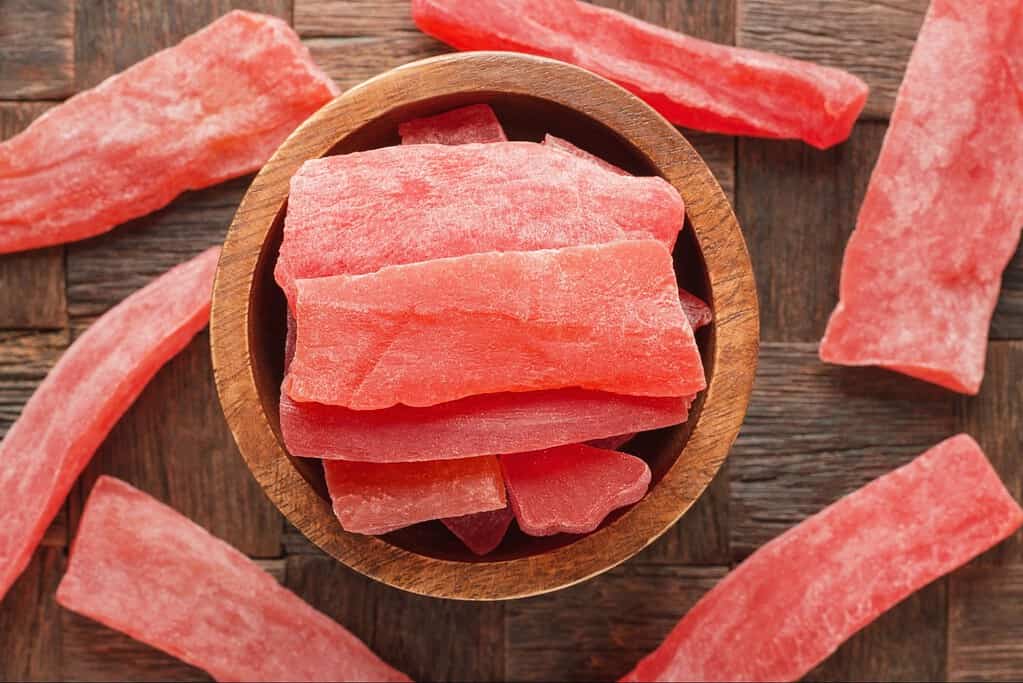 Dehydrated watermelon slices as healthy dog treats on wooden surface. Great snack for dogs, natural and tasty, perfect for training or rewarding.