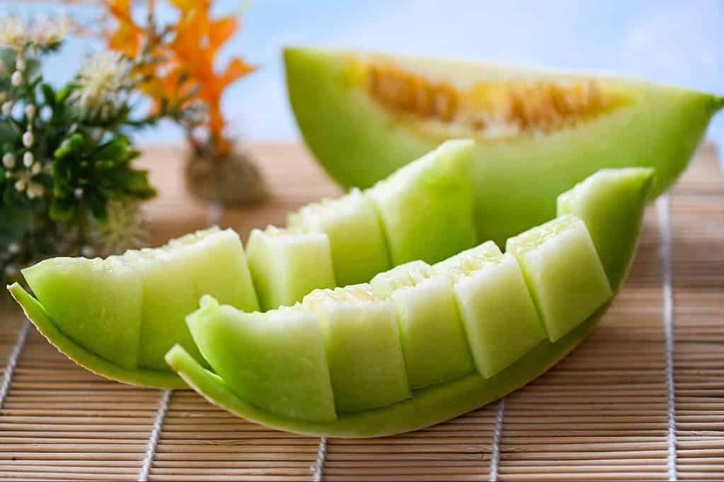Bright green melon slices with seeds, refreshing healthy fruit snack, perfect for summer days.