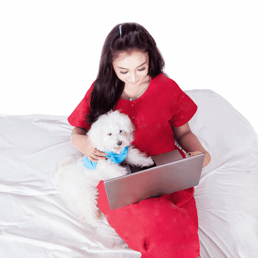 Cute woman with a small white dog on her lap using a laptop.