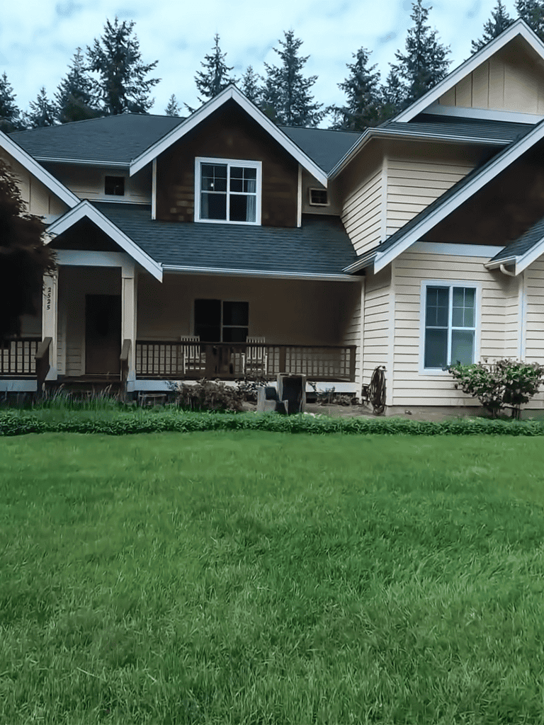 House with a large front porch, multiple gables, and well-maintained lawn. Modern farmhouse style with charming architecture.