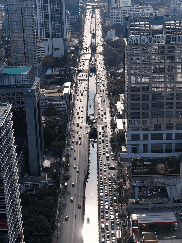 Aerial view of busy urban city street with heavy traffic and high-rise buildings in the background.