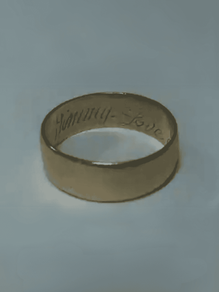 Close-up of a personalized gold ring with engraved message, ideal for special occasions.