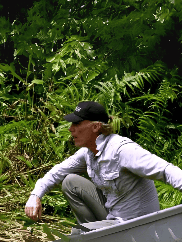 Female explorer navigating lush green jungle environment with outdoor gear.