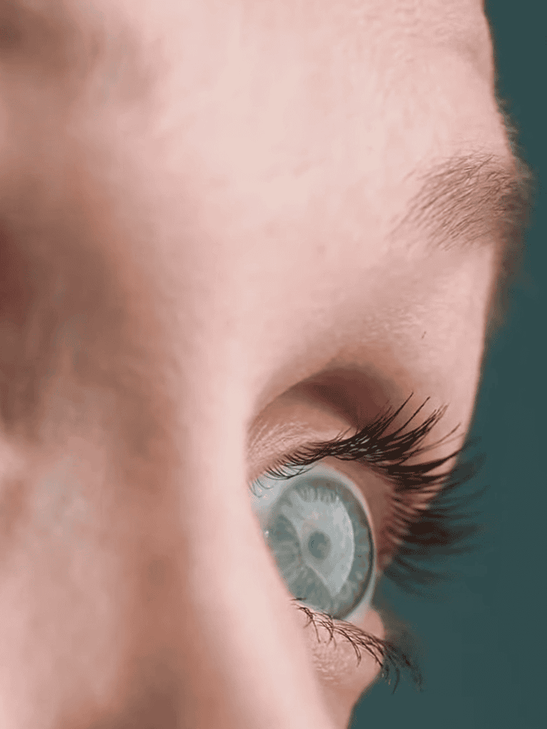 Close-up of a person's bright blue eye with detailed eyelashes and skin texture.