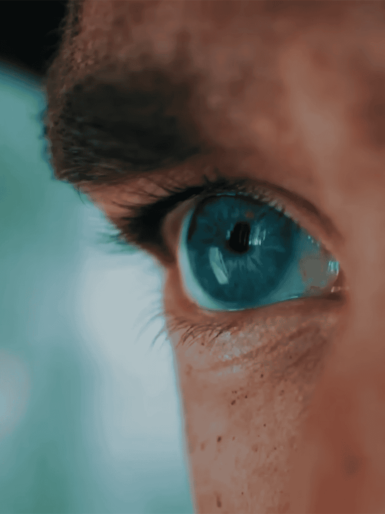 Close-up of a human eye showing detailed iris and eyelashes.