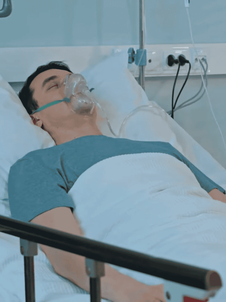 Patient resting in hospital bed with oxygen mask for medical treatment and recovery.