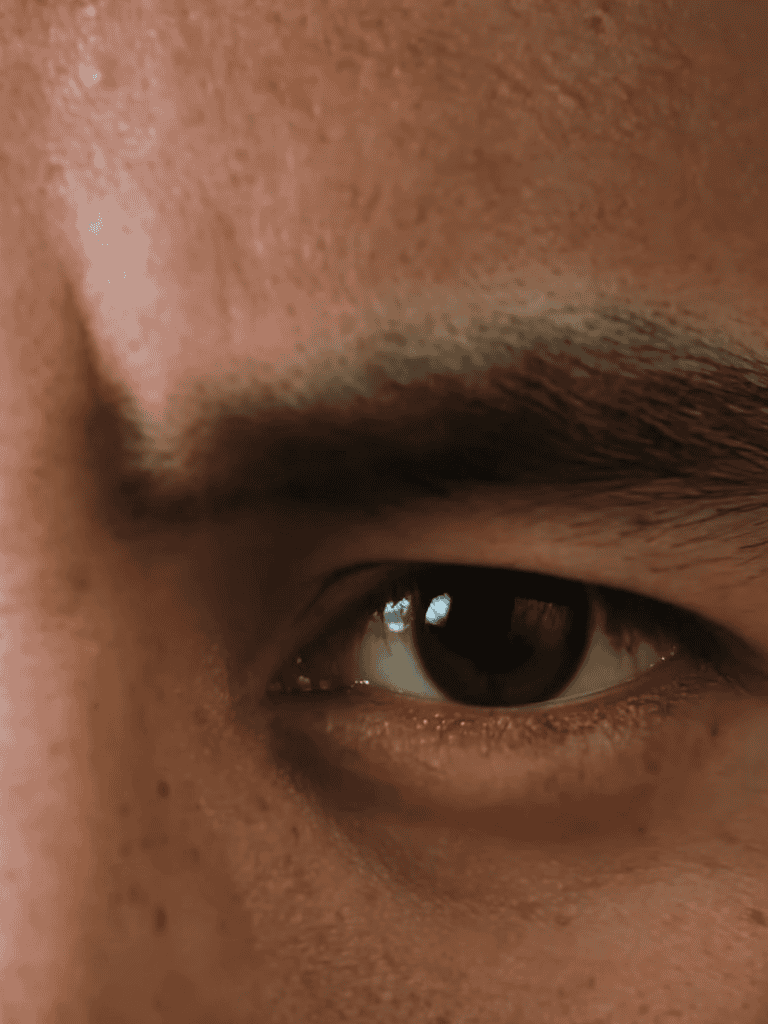 Close-up of a person's eye highlighting eyelashes and skin texture.