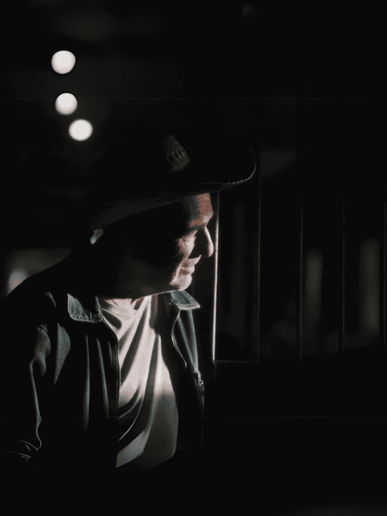 Person relaxing in shadowy environment emphasizing comfort and care.