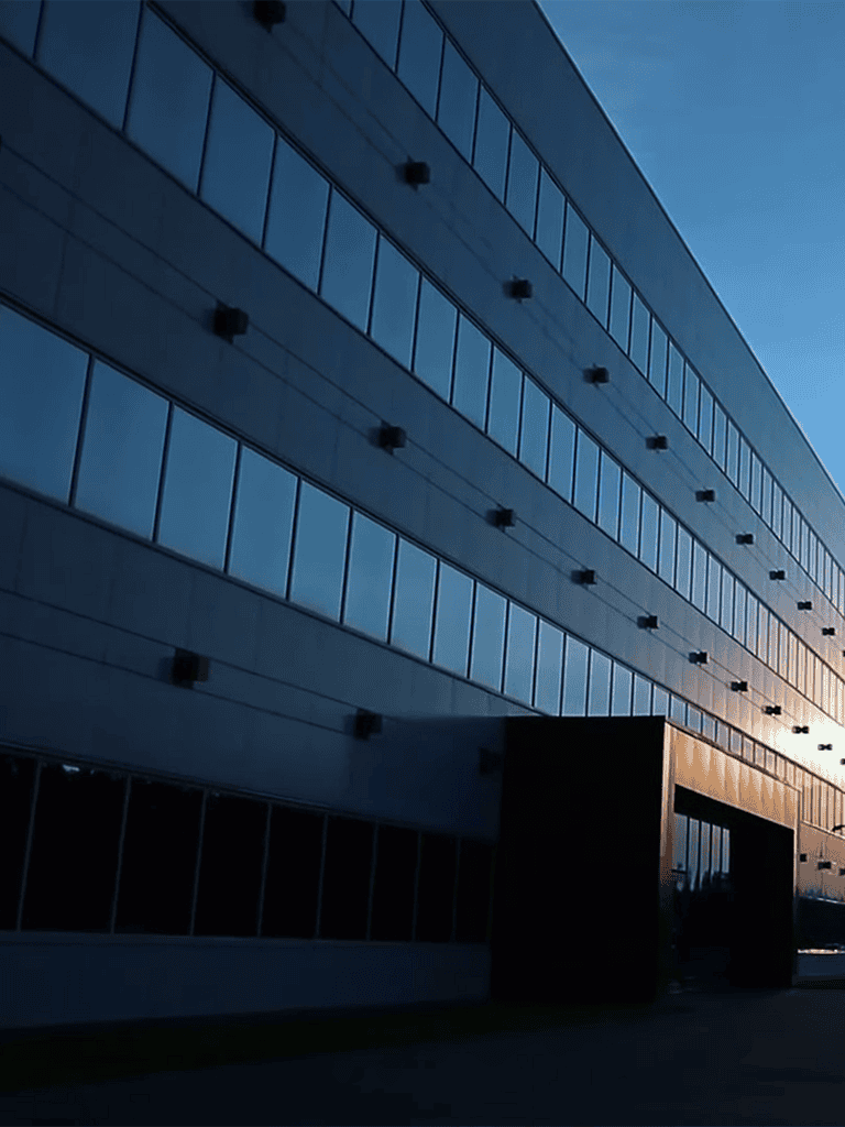 Modern office building with reflective glass windows at sunset, showcasing sleek architecture and urban design excellence.