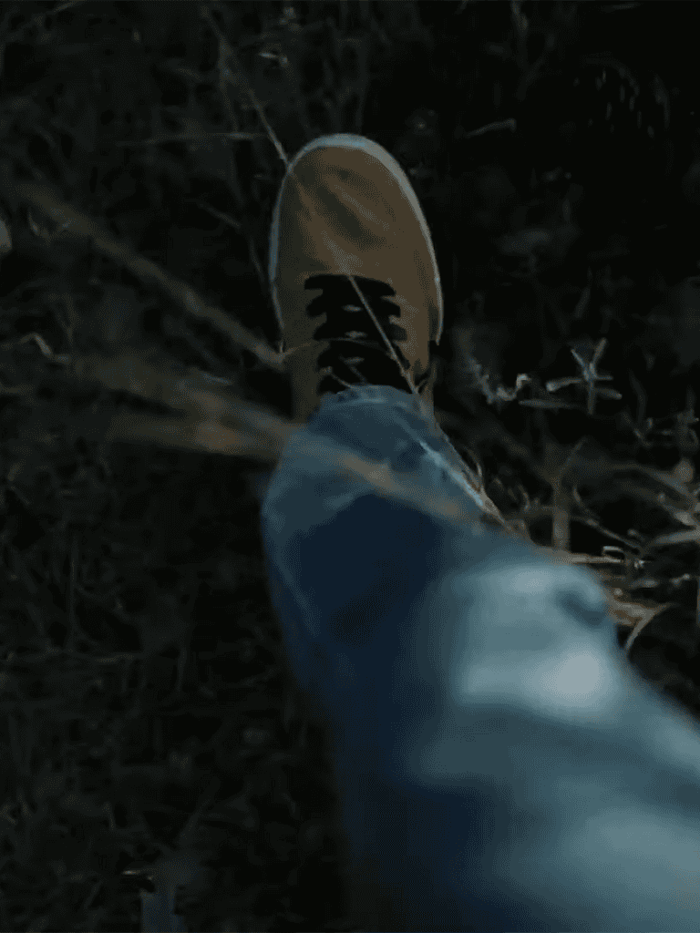 Exploring nature with casual shoes, foot in dirt during outdoor walk, ground-level view showing ground and footwear.