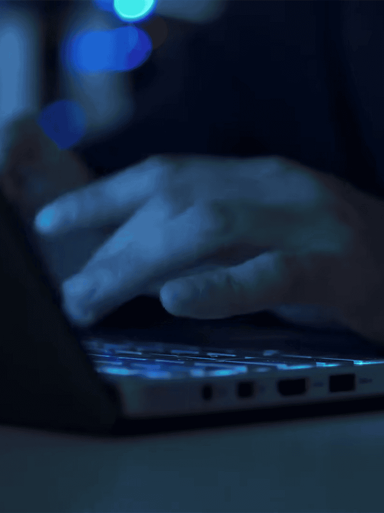 Alt text: Hand using a smartphone with a dog tracker app, illuminated in low light.