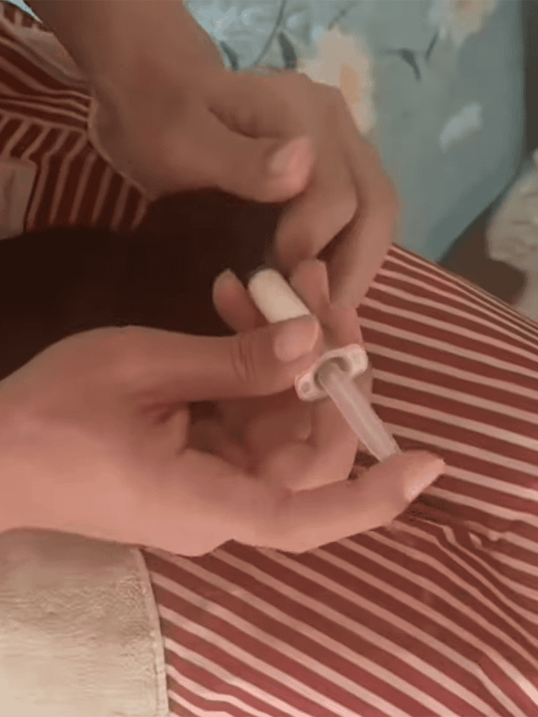 Close-up of hands feeding a cute puppy with a syringe, highlighting pet care and health support.