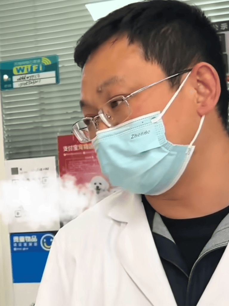 Close-up of a healthcare worker in a face mask and glasses at a vaccination clinic.